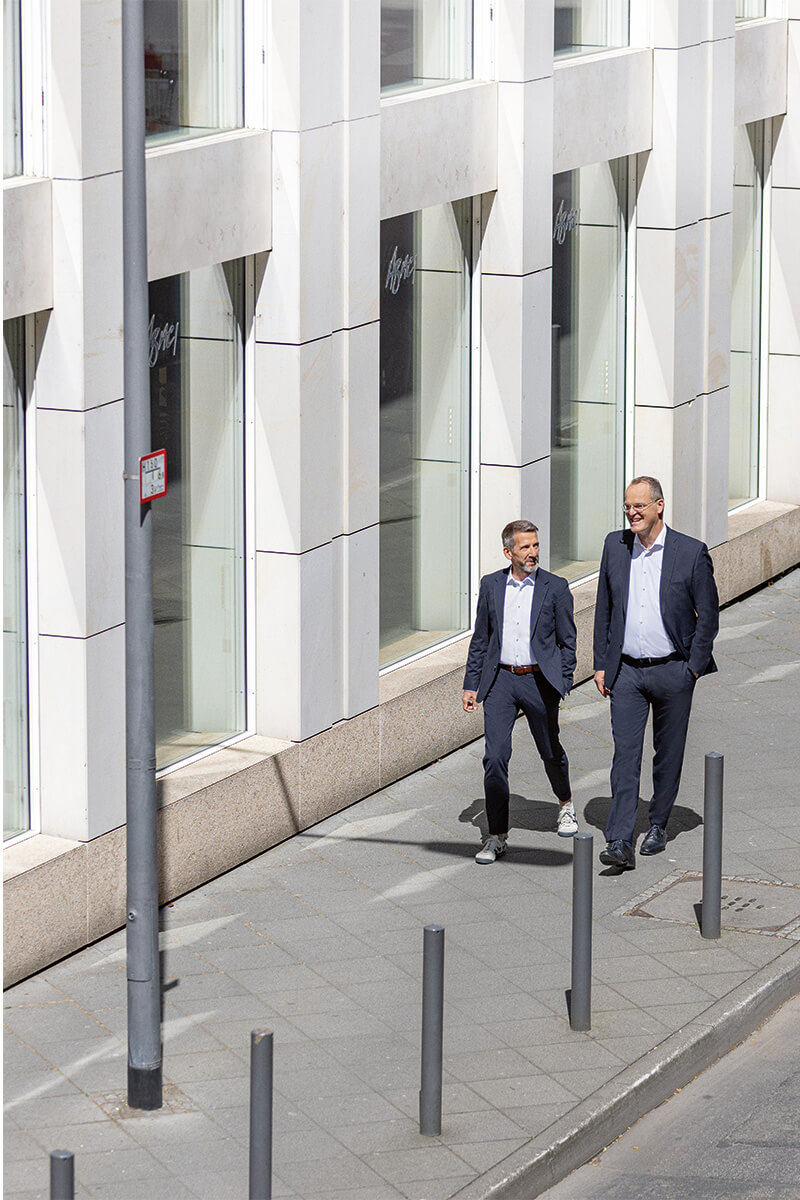 Zwei Personen laufen gemeinsam eine Straße entlang